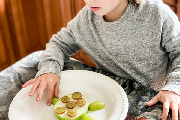 Child assembling turtle snack