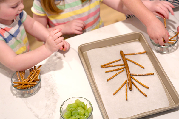 Little girls adding grapes to tray