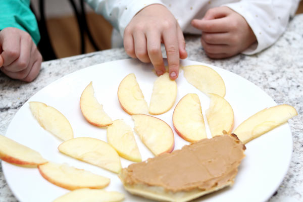 Preschooler adding apples to octopus snack