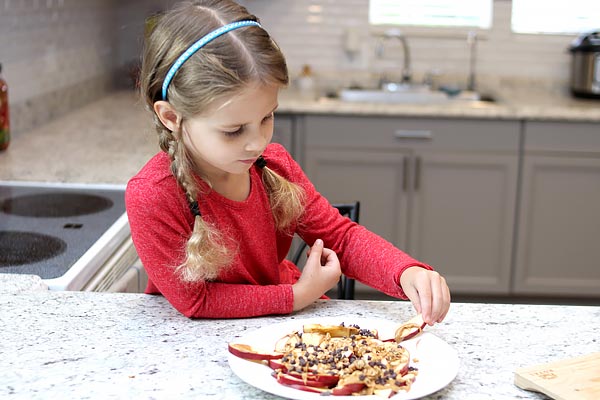 Child enjoying apple nachos