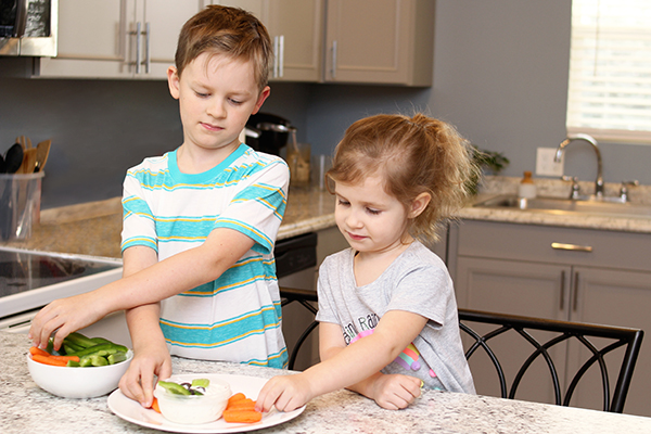 Child arranging veggies on plate