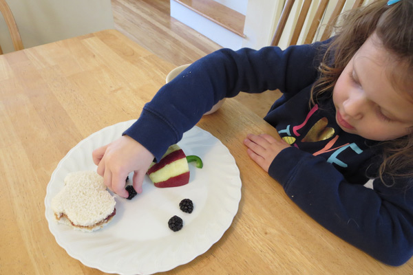 Preschooler adding blackberries