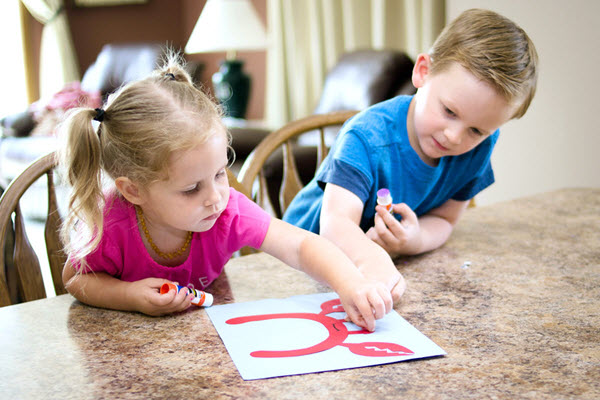 children applying eyes to letter c craft