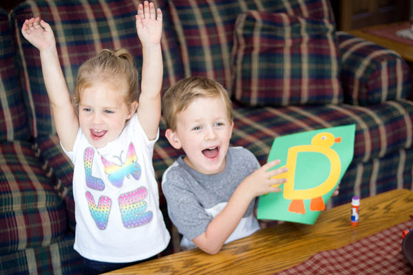 two children complete letter d craft