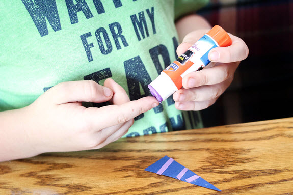 child gluing his letter n craft