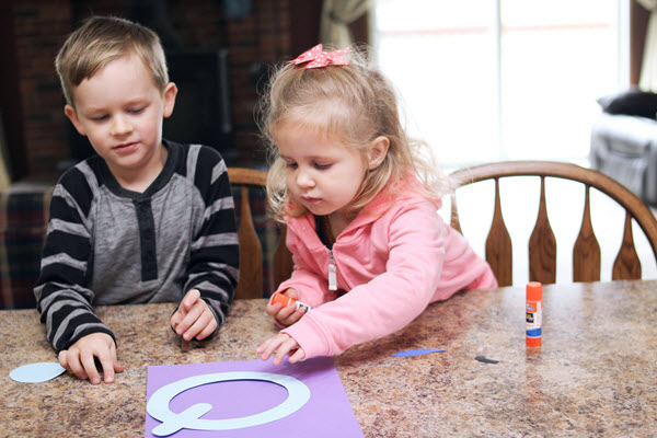 children assembling their letter q craft