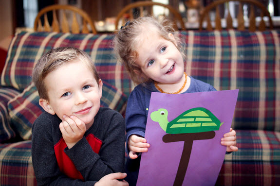 children smiling with their finished letter T craft