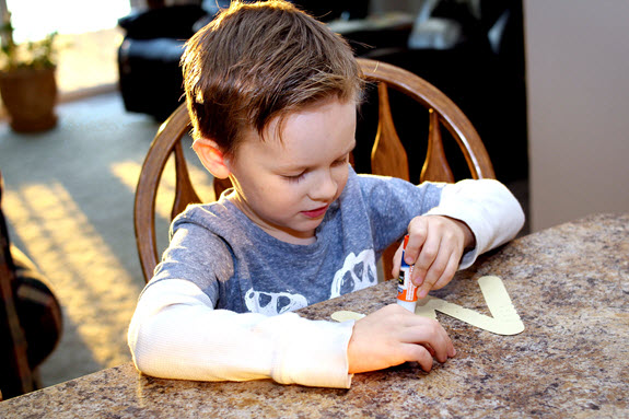 boy gluing letter w craft