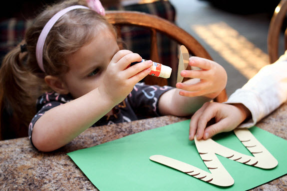 girl gluing letter w craft