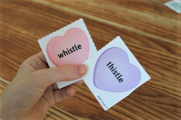 child holding rhyming activity cards