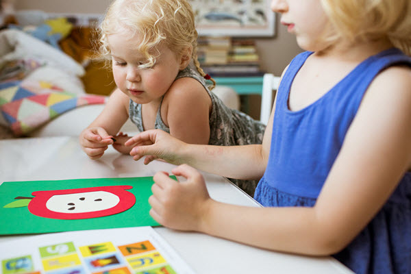 little girl adding a seed to her lowercase a craft