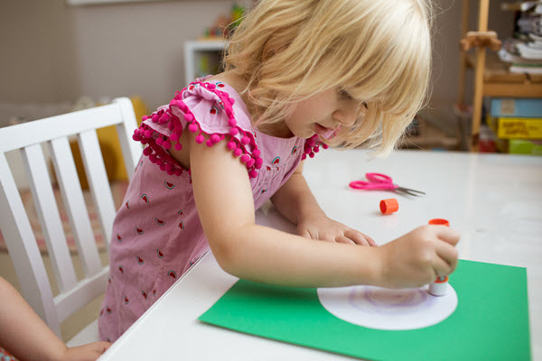 child gluing lowercase letter c craft