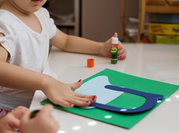 child attaches letter N to uppercase n craft