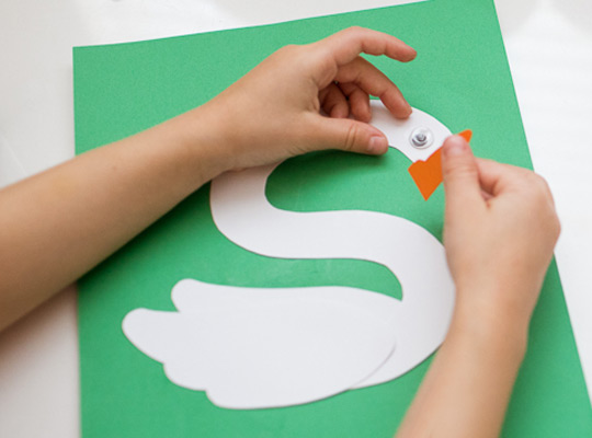 child puts a beak on her lowercase s craft