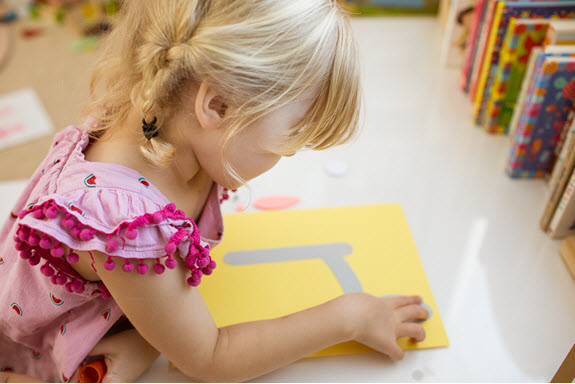 child assembles her lowercase L craft
