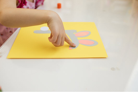 child glues an eye to her lowercase r craft