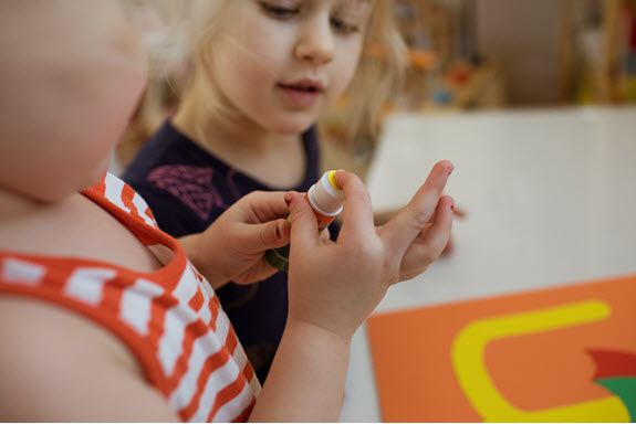 child glues dot for her lowercase u craft