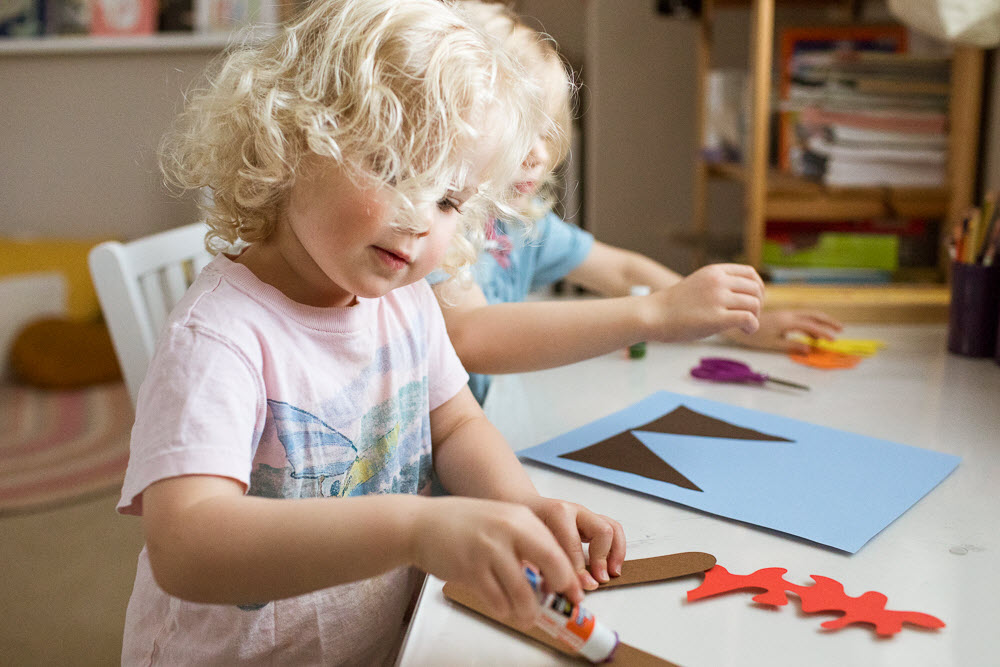 child glues a letter for her lowercase v craft