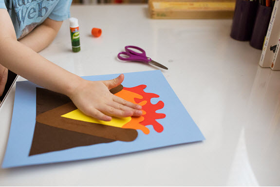 child adds piece to her lowercase v craft