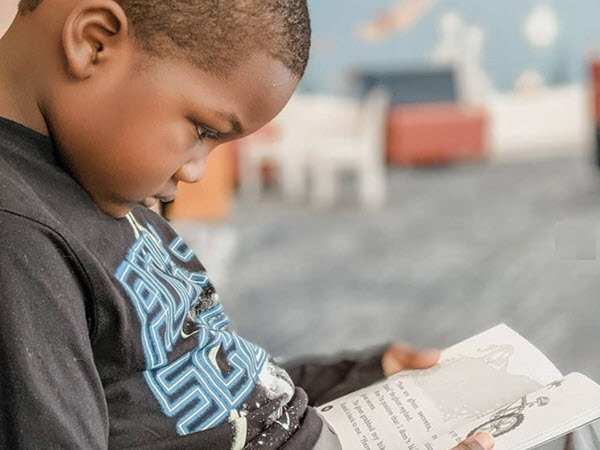 boy reading a book on the floor