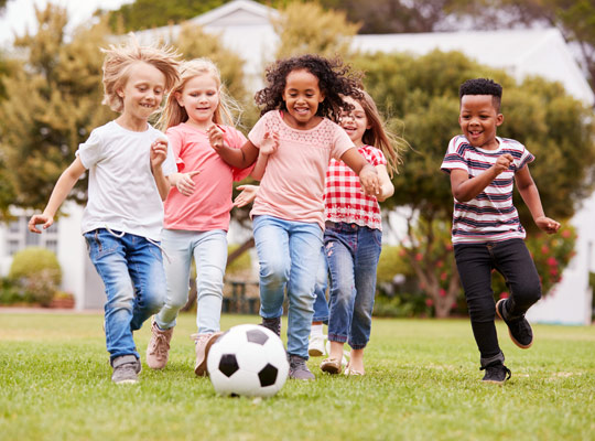 children running after a soccer ball